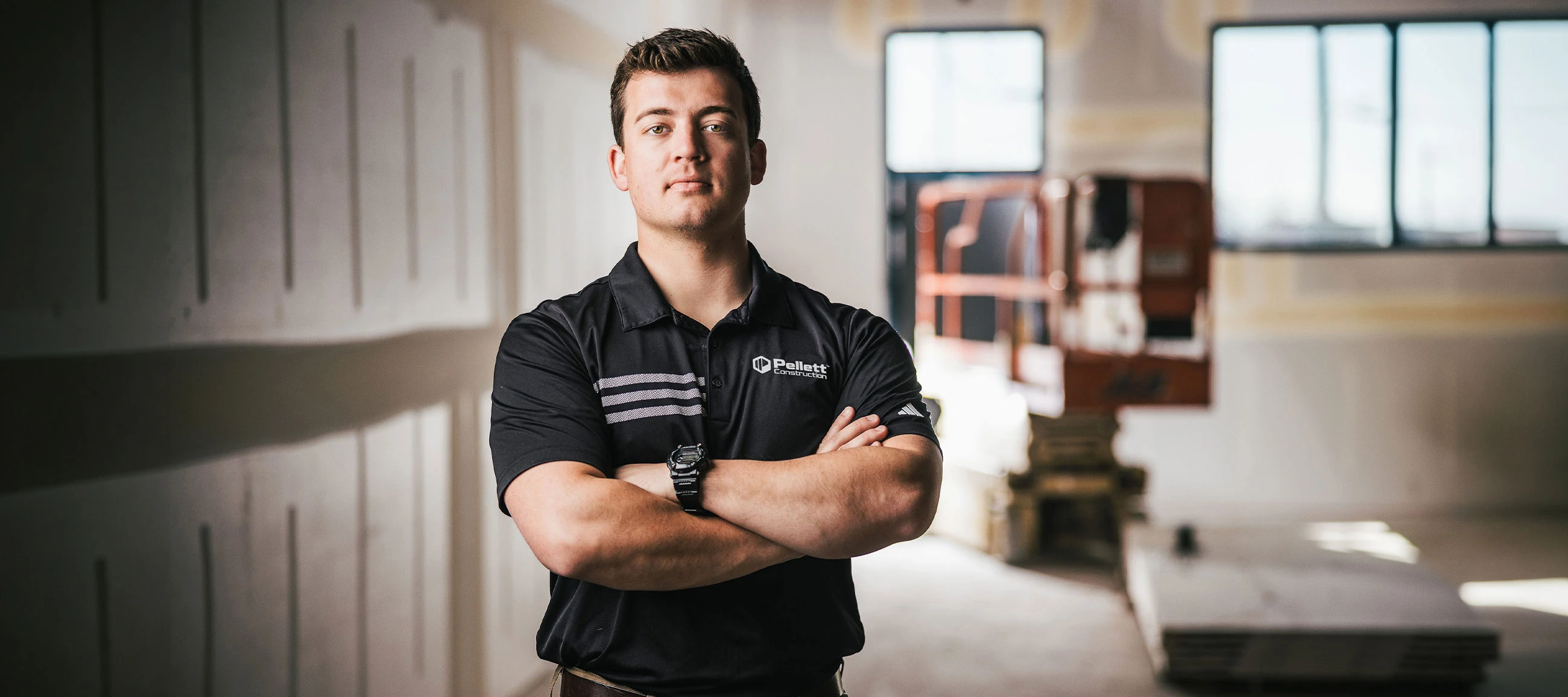 A headshot of a Pellett Construction employee standing at a job site